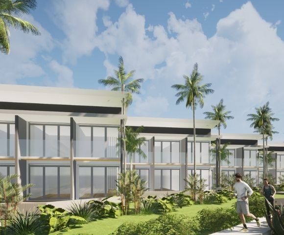 A modern, multi-story building with large windows and balconies is surrounded by lush tropical foliage and palm trees, with two people jogging on a path in the foreground under a cloudy blue sky.