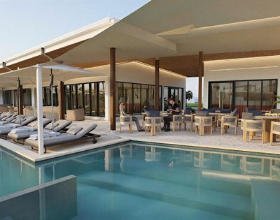 A modern resort pool area with lounge chairs and an outdoor dining patio.