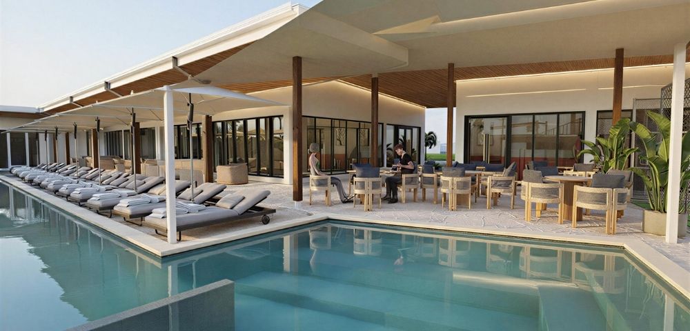 A modern resort pool area with lounge chairs and an outdoor dining patio.