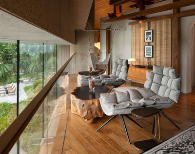 Modern living space with wooden floors, seating area, and large windows
