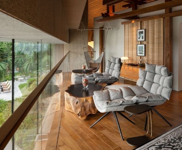 Modern living space with wooden floors, seating area, and large windows