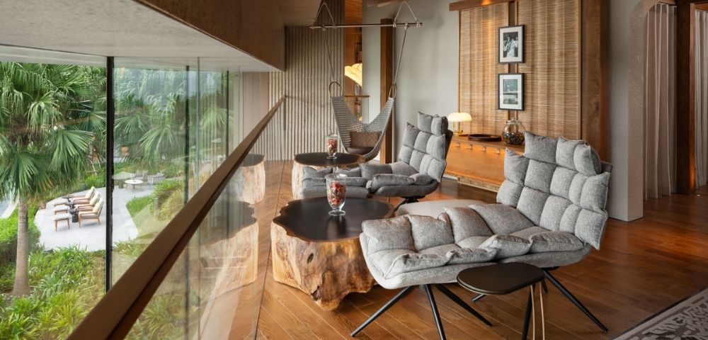 Modern living space with wooden floors, seating area, and large windows