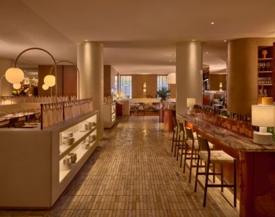 An elegant restaurant interior with a marble bar, seating, and dining areas.