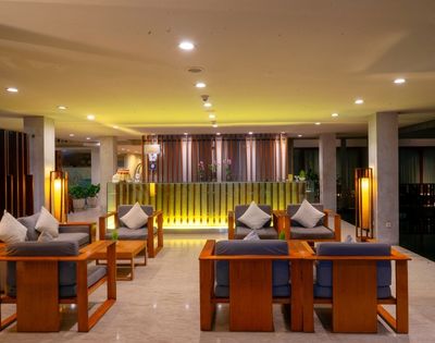 A hotel lobby with a reception desk and seating area.