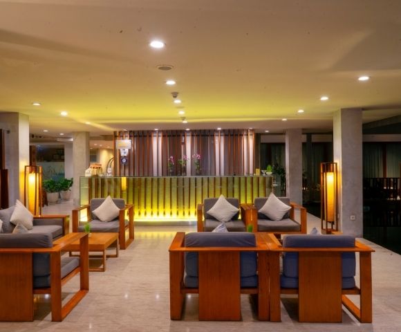 A hotel lobby with a reception desk and seating area.