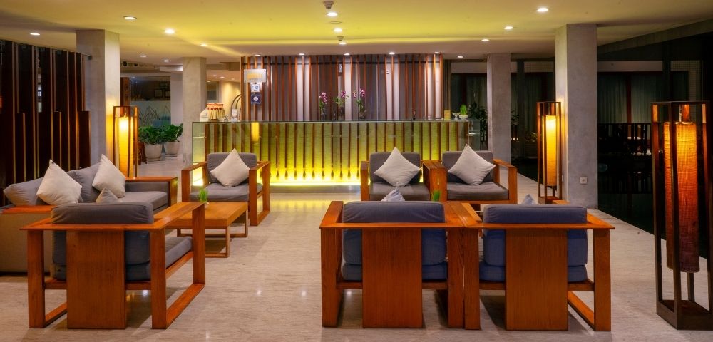 A hotel lobby with a reception desk and seating area.