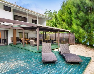 Spacious beachfront veranda with lounge chairs facing tropical gardens and the sea
