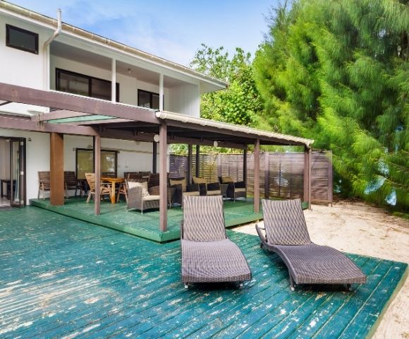 Spacious beachfront veranda with lounge chairs facing tropical gardens and the sea