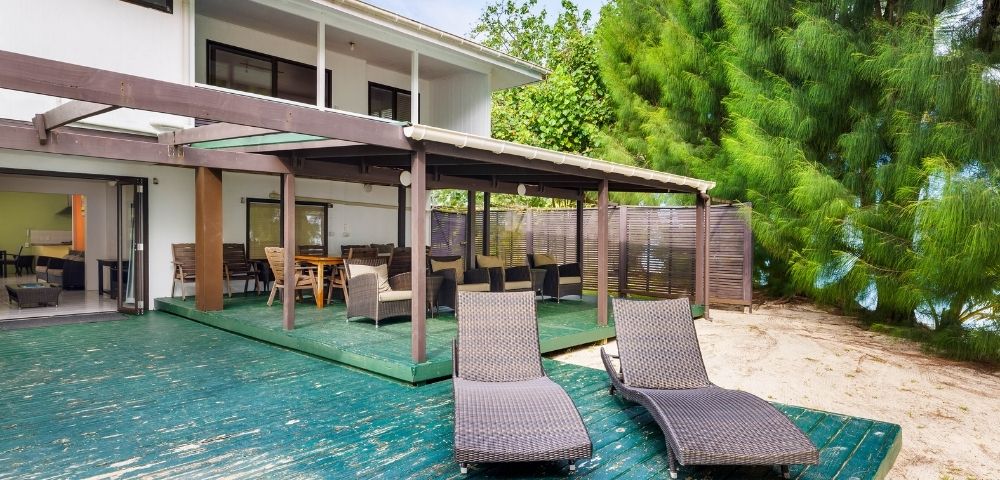 Spacious beachfront veranda with lounge chairs facing tropical gardens and the sea