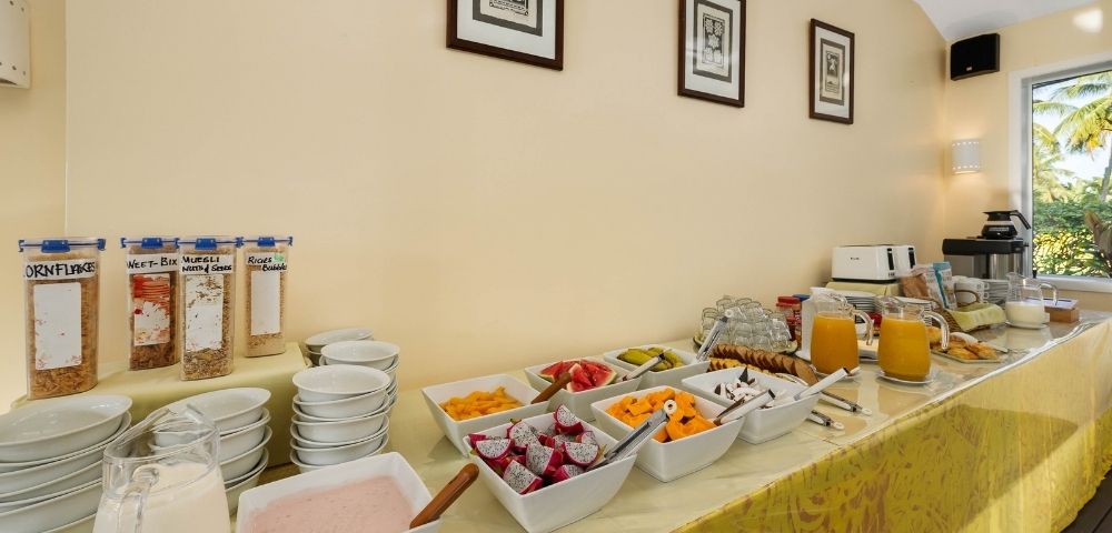 Buffet breakfast station displaying breads, cereals, and beverage options