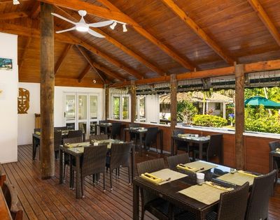 Open-air restaurant dining area with wooden furnishings