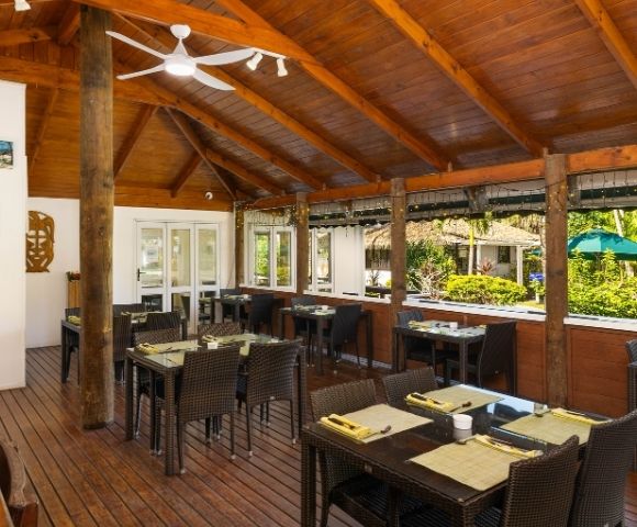 Open-air restaurant dining area with wooden furnishings