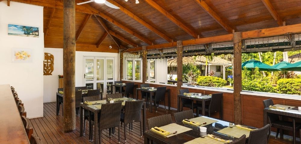 Open-air restaurant dining area with wooden furnishings