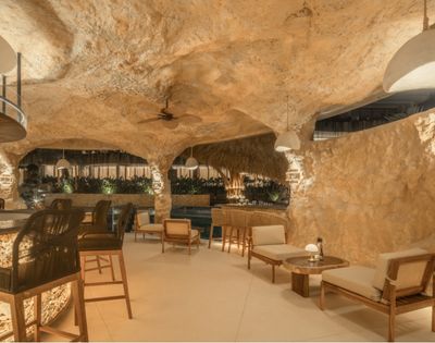 Spacious cave-style lounge featuring seating areas, stone walls, and a relaxed atmosphere