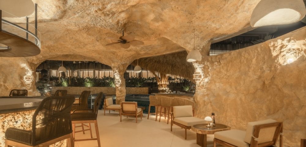 Spacious cave-style lounge featuring seating areas, stone walls, and a relaxed atmosphere