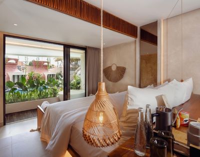 Bright suite interior with floor-to-ceiling windows overlooking tropical resort surroundings