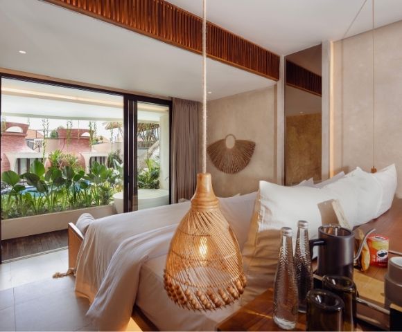 Bright suite interior with floor-to-ceiling windows overlooking tropical resort surroundings
