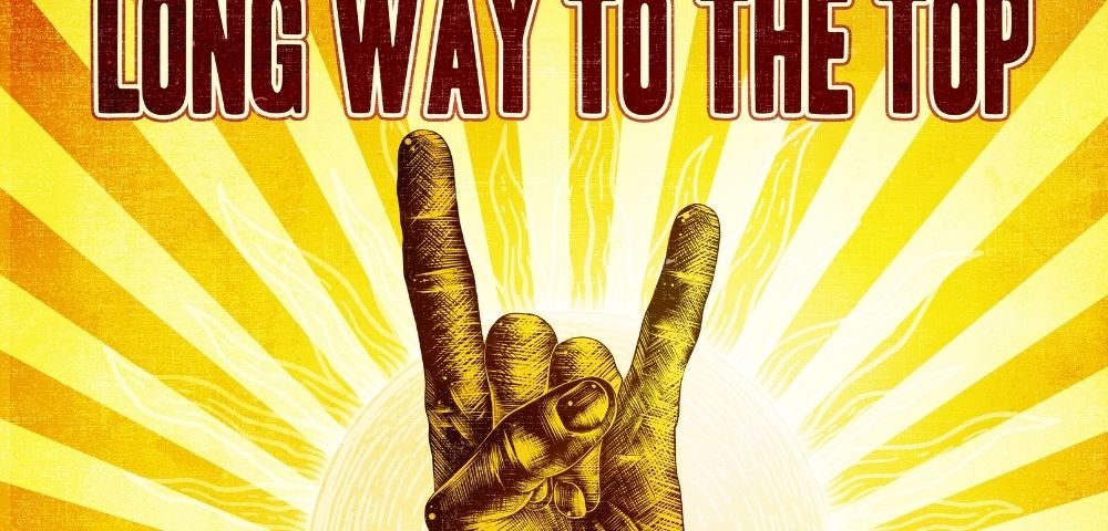 Rock hand gesture in front of a sunburst with the text 
