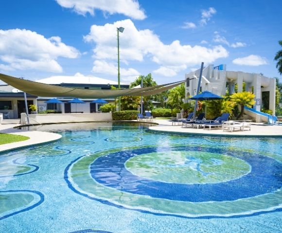 Circular resort pool with tropical surroundings and outdoor seating