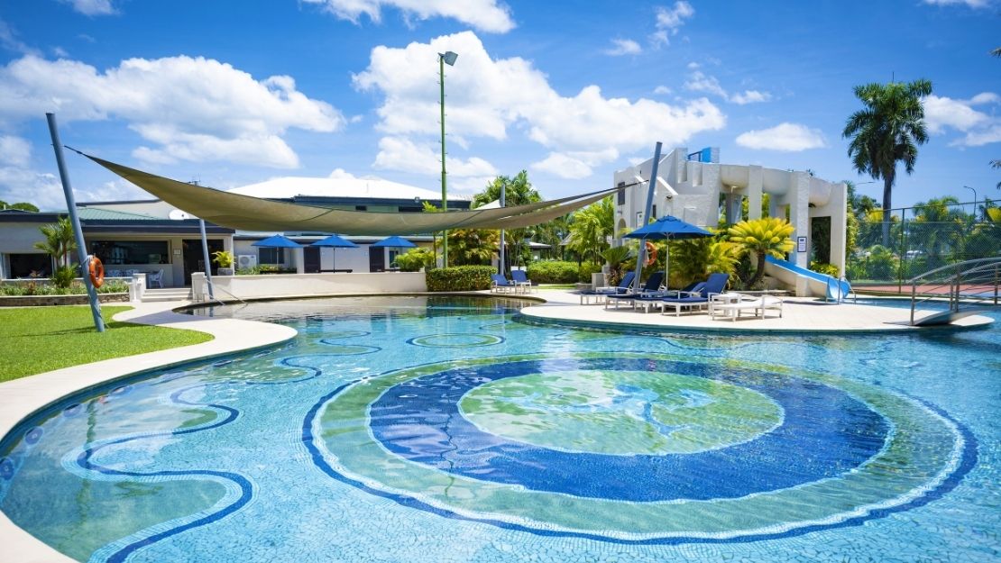 Circular resort pool with tropical surroundings and outdoor seating