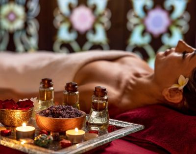 Guest receiving a relaxing spa massage surrounded by aromatic treatment products