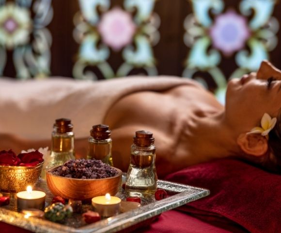 Guest receiving a relaxing spa massage surrounded by aromatic treatment products