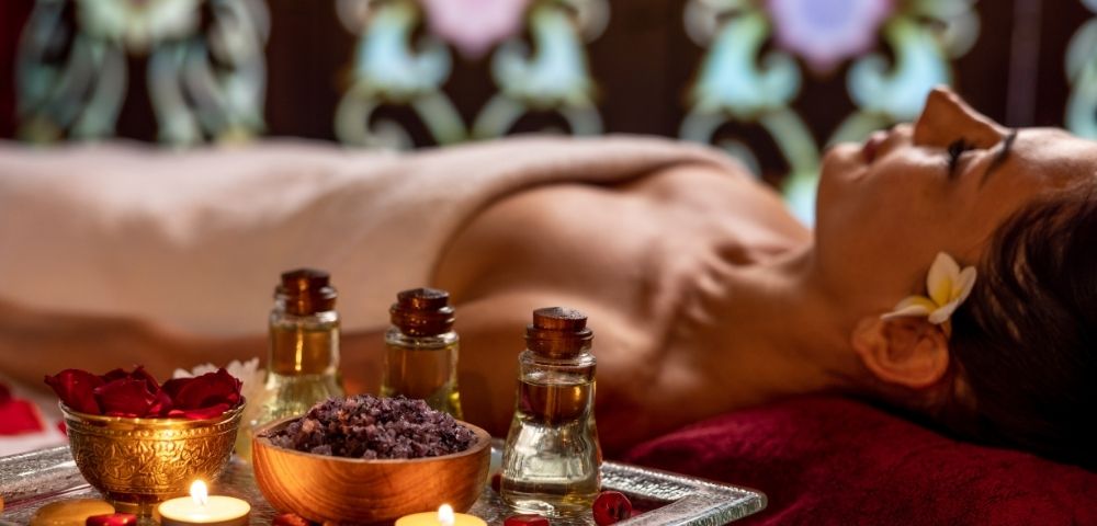 Guest receiving a relaxing spa massage surrounded by aromatic treatment products