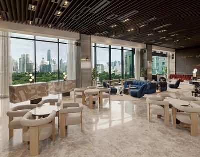 Spacious modern lounge with floor-to-ceiling windows, beige chairs, blue sofas, marble floors, and city skyline views in the background.