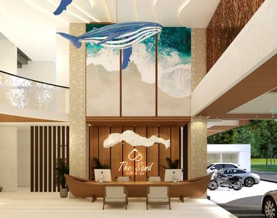 Spacious resort reception area with a decorative central desk, high ceilings, natural light, and landscaped outdoor views