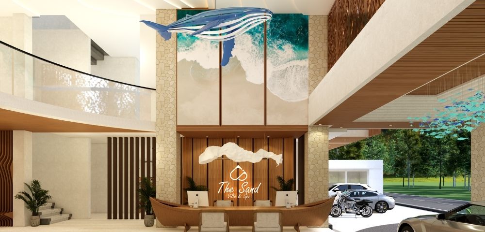 Spacious resort reception area with a decorative central desk, high ceilings, natural light, and landscaped outdoor views