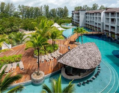 Aerial-style view of resort pools, tropical gardens, and surrounding buildings