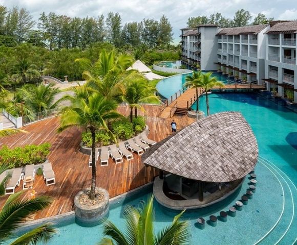 Aerial-style view of resort pools, tropical gardens, and surrounding buildings