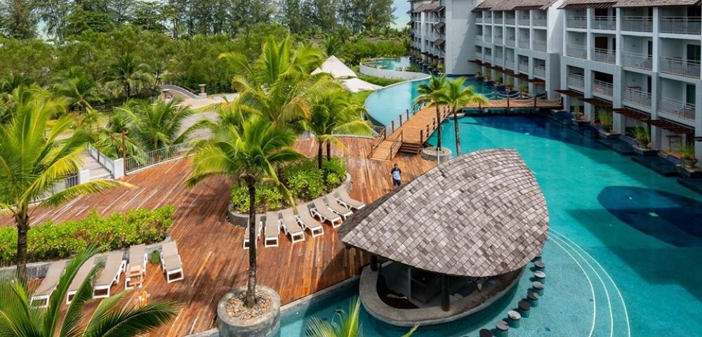 Aerial-style view of resort pools, tropical gardens, and surrounding buildings