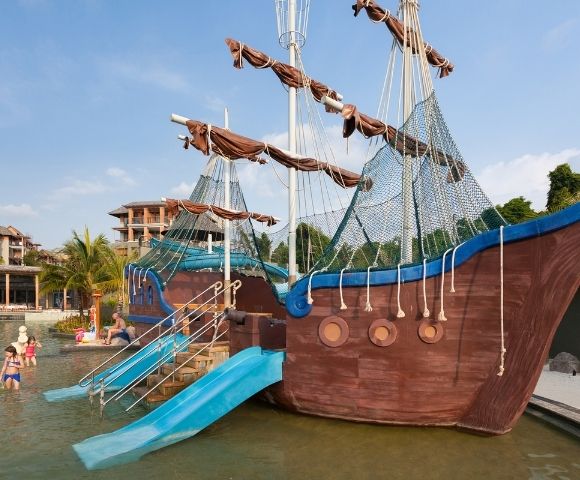 Children's water play area featuring a pirate ship structure and slides