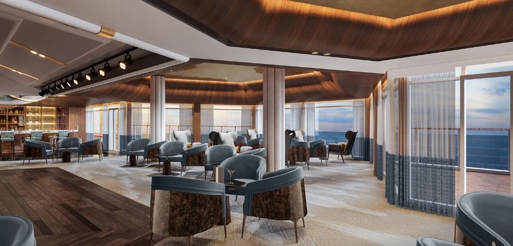 Luxurious lounge area with plush seating, a bar, and panoramic ocean views through floor-to-ceiling windows.