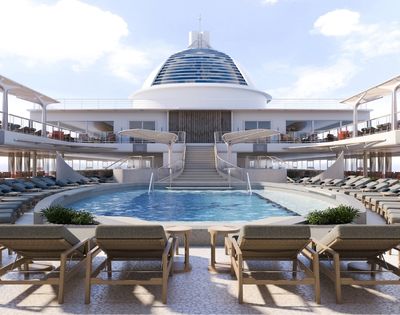 An empty deck area of a cruise ship with a swimming pool, rows of lounge chairs, and a bar area.