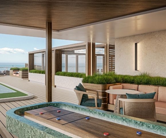 A modern outdoor lounge area with a shuffleboard court, a full-size shuffleboard court, seating, and tables overlooking the ocean.
