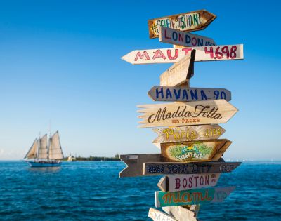 A wooden signpost displaying multiple directional arrows, indicating various destinations.