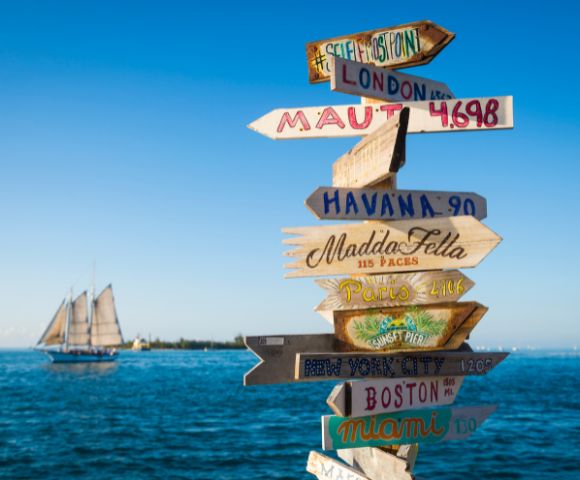 A wooden signpost displaying multiple directional arrows, indicating various destinations.