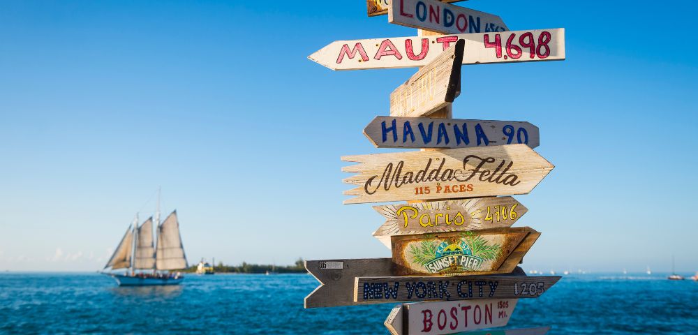 A wooden signpost displaying multiple directional arrows, indicating various destinations.