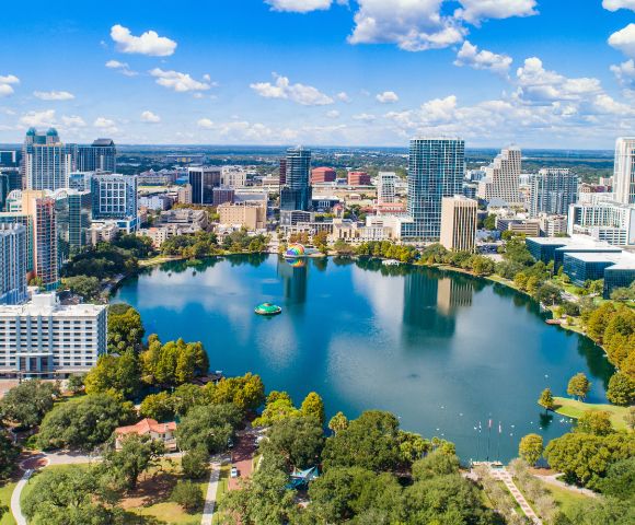 A vibrant skyline of Orlando, showcasing iconic attractions and a bustling atmosphere, popular among tourists.