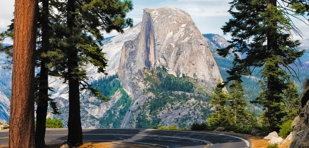 Half Dome and a winding section of Glacier Point Road in Yosemite National Park, California.
