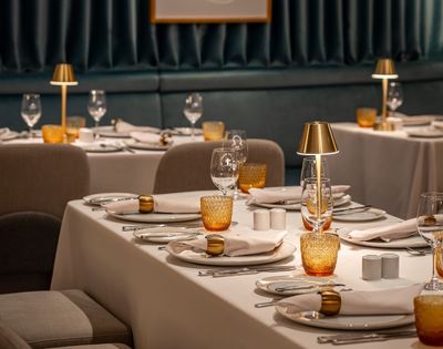 Private dining setup with table settings and decorative artwork in the Amphora restaurant.
