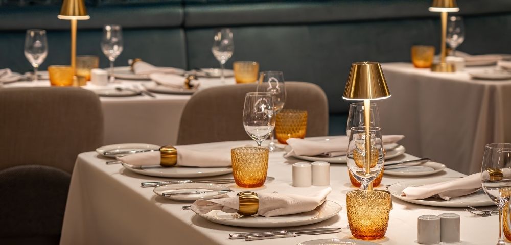 Private dining setup with table settings and decorative artwork in the Amphora restaurant.