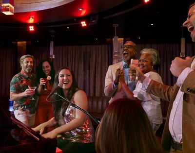 Live entertainment in a piano bar with guests gathered around the performance area.