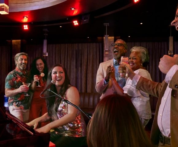Live entertainment in a piano bar with guests gathered around the performance area.