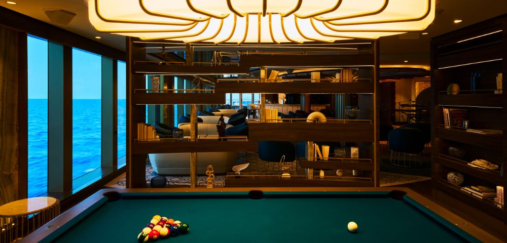 A green billiard table with a rack of colorful balls and a white cue ball.