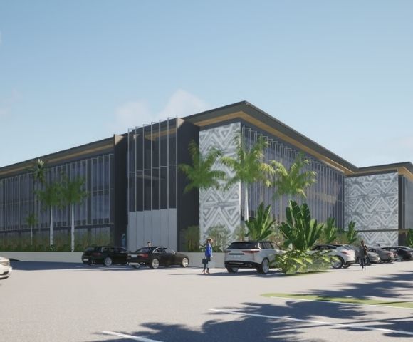 A modern architectural rendering of a multi-story office building with dark gray and white patterned facade elements, a dark roof with gold trim, and extensive floor-to-ceiling windows, set amidst lush palm trees and tropical foliage, with a paved parking lot in the foreground containing several parked cars.