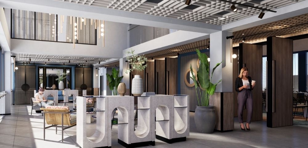 A modern hotel lobby featuring stylish seating arrangements, large potted plants, decorative lighting, and contemporary design elements.