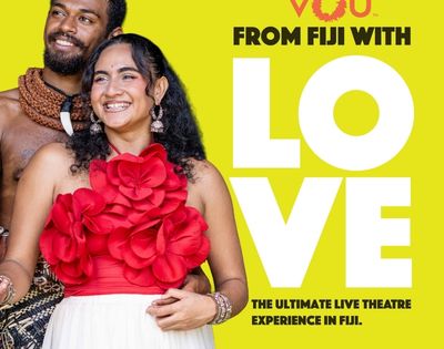 A couple dressed in traditional Fijian attire, with the woman wearing a red dress adorned with large flowers, smiling against a bright yellow background featuring the text 